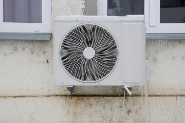 Soğuk kış mevsiminde buz saçaklarıyla açık hava havalandırma ünitesi.