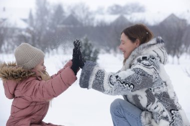 Anne ve Kızı Karlı Kış manzarasında birlikte vakit geçiriyorlar.