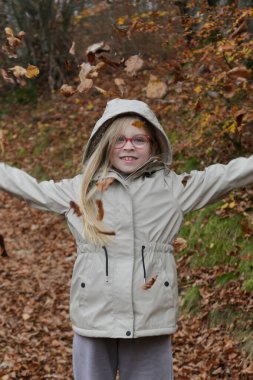 Renkli Sonbahar Yapraklarını Ormana Atan Küçük Kız Neşeli Çocukluk, Mevsimsel Yaşam Tarzı ve Doğa Özgürlüğü Konsepti