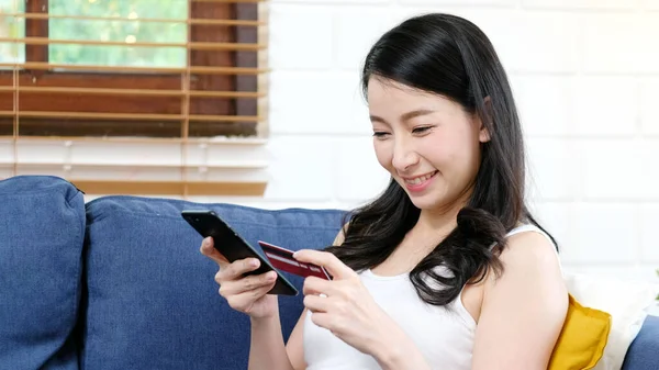 Online phone payment by credit card at home, Asian woman using mobile phone make digital money payment for shopping, Happy asia female girl and smartphone for E commerce, online banking, mobile app, business finance technology