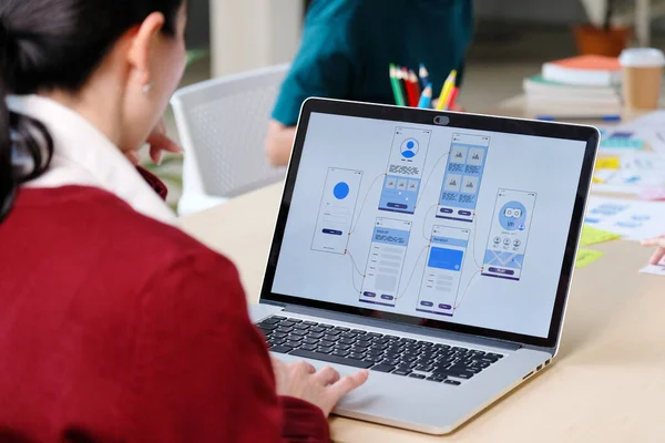 Web sitesi tasarımcısı, Yaratıcı Planlama Telefon Uygulaması Geliştirme şablonu yerleşim şeması kablo şeması tasarımı, Kullanıcı deneyimi konsepti, Ofiste akıllı telefon uygulaması üzerinde çalışan Asyalı genç kadın UX tasarımcısı