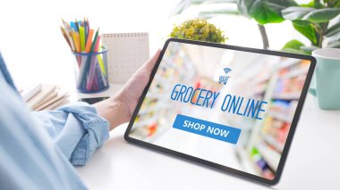 El ele tutuşma dijital tableti ile market online alışveriş uygulaması cihaz ekranında bulanık süpermarket arka planı, iş ve teknoloji, yaşam tarzı konsepti