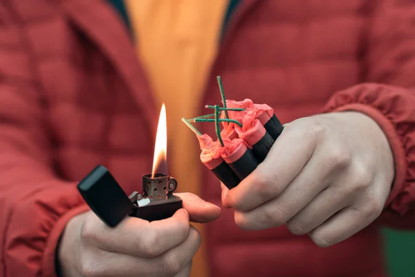 Kırmızı ceketli adam birkaç fişek yakıyor.