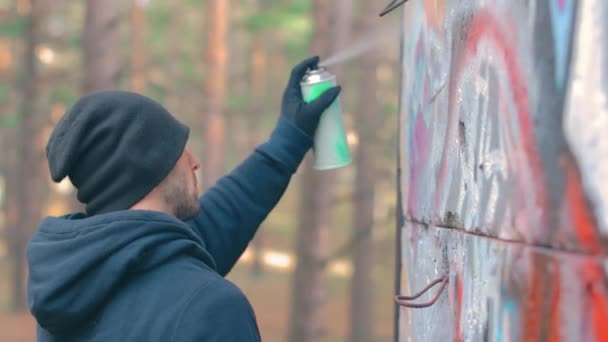 Grafiti çizen genç adam sprey boya kutusu kullanıyor. — Stok video