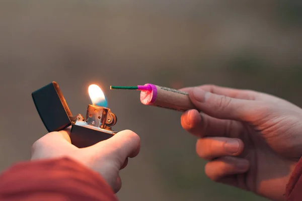 Jongeman verlicht vuurwerk in zijn hand — Stockfoto