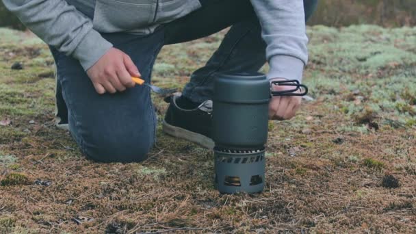 Vandrare kokar pasta med konserverad gryta i en skog — Stockvideo