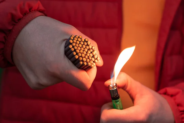 Hombre de chaqueta roja iluminando muchos petardos pequeños —  Fotos de Stock