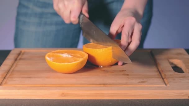 Gospodyni Cięcie Duży soczysty pomarańcza w domu — Wideo stockowe
