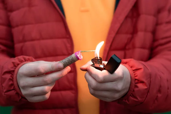 Homem de jaqueta vermelha acendendo fogo de artifício em sua mão — Fotografia de Stock