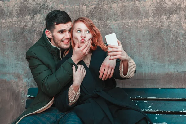 Veselý pár dělat selfie na lavičce — Stock fotografie