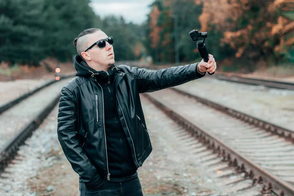 Youthful Guy Making Selfie Using Action Camera at Forest