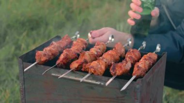 Barbekü yapan adam dışarıda et yiyor.