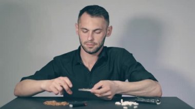 El yapımı sigarayı yuvarlayan adam.