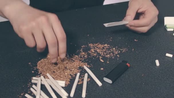 Mann dreht eine handgemachte Zigarette — Stockvideo