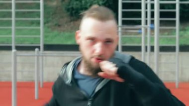 Genç Sakallı Adam dışarıda boks antrenmanı yapıyor.