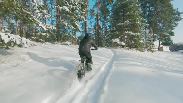 Ciclista montando en bicicleta eléctrica en la nieve — Vídeo de stock