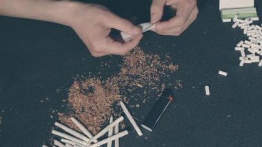 El yapımı sigarayı yuvarlayan adam.