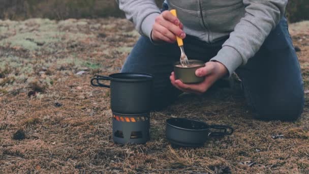 Турист готовит пасту с консервированным тунцом в лесу — стоковое видео