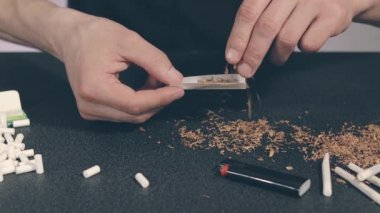 El yapımı sigarayı yuvarlayan adam.