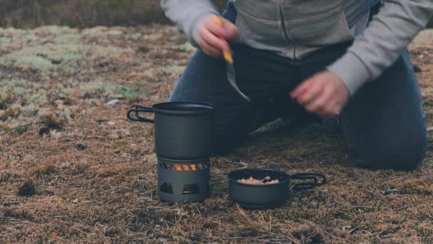 Turistický je vaření těstoviny s konzervy tuňáka v lese — Stock video