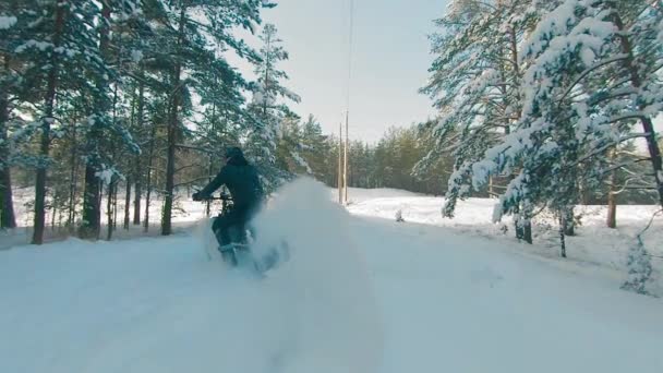 Ciclista montando en bicicleta eléctrica en la nieve — Vídeo de stock