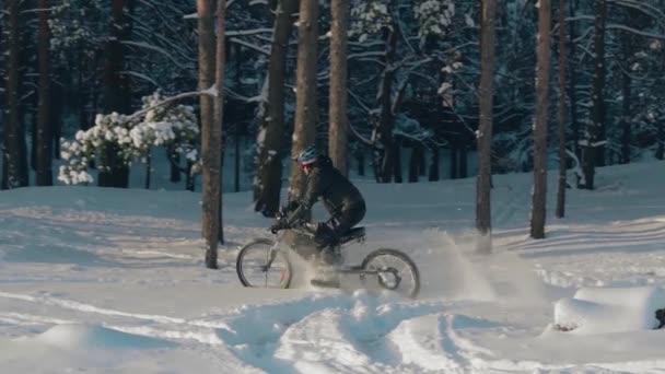 Ciclista montando en bicicleta eléctrica en la nieve — Vídeo de stock