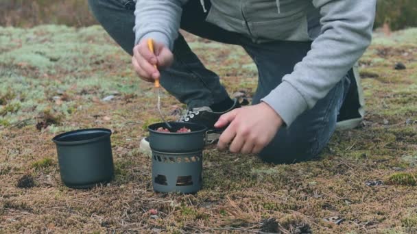 Turysta gotuje makaron z puszką Gulasz w lesie — Wideo stockowe