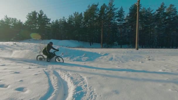 Ποδηλάτης Ιππασία με ηλεκτρικό ποδήλατο στο χιόνι — Αρχείο Βίντεο