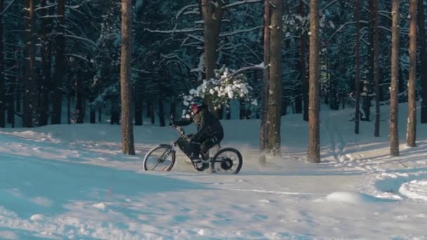 Велосипедист на электрическом велосипеде в снегу — стоковое видео