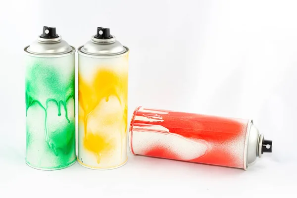 Três latas coloridas da pintura do pulverizador no fundo branco — Fotografia de Stock