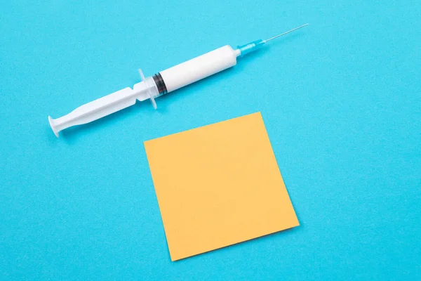 Концепція вакцинації або ревакцинації - медичний шприц на синьому столі — стокове фото