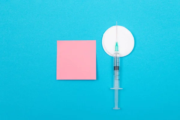 Концепція вакцинації або ревакцинації - медичний шприц на синьому столі — стокове фото