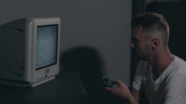 Ovládání mysli - Zombified Man in White T-shirt Switches Channels on the TV — Stock video