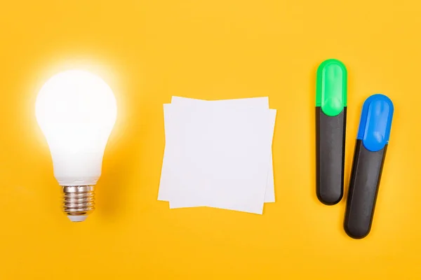 Lámpara de ahorro de energía brillante con papel blanco — Foto de Stock
