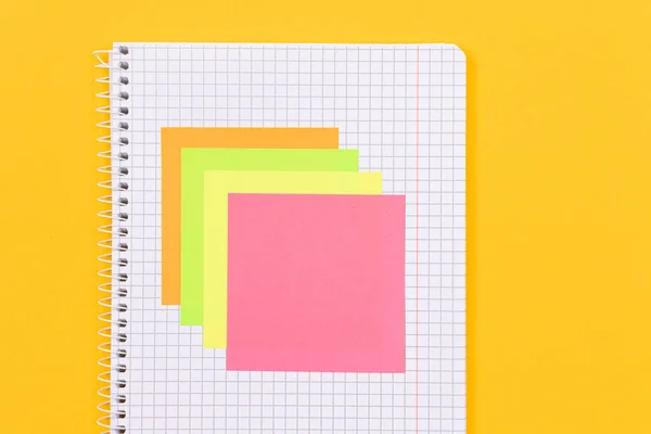 Ett anteckningsblock med klisterlappar på gula bordet — Stockfoto
