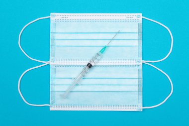 Aşı ya da Yeniden Aşılama Konsepti - Mavi Masa Üzerine Bir Tıbbi Şırınga