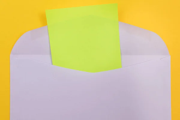 Envelope violeta com folha verde em branco de papel no interior — Fotografia de Stock