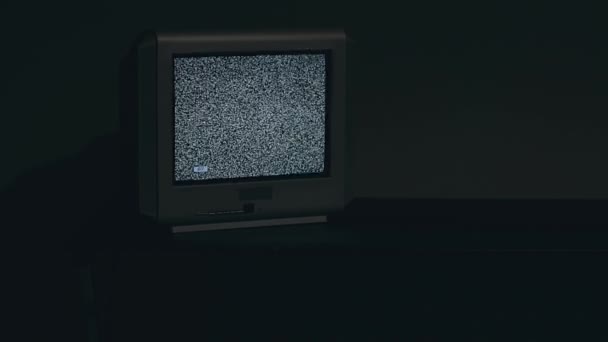Побите телебачення. Старе срібне телебачення на чорному столі в темній кімнаті — стокове відео