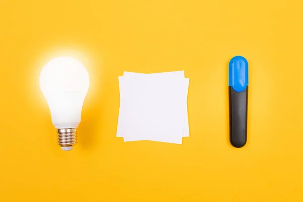 Glödande energisparlampa med vitbok — Stockfoto