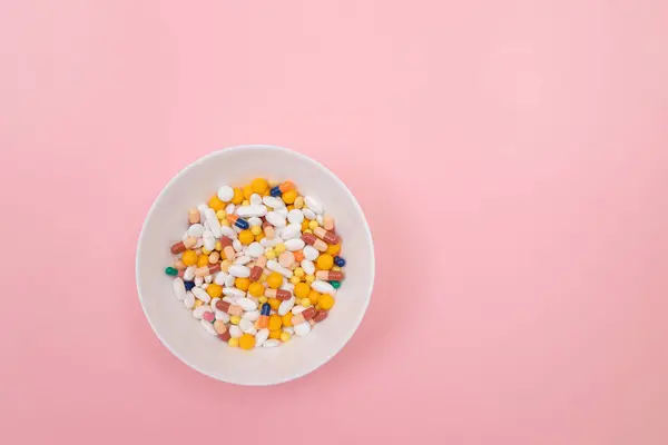 Industria farmacéutica y medicamentos - Píldoras coloreadas en el plato blanco — Foto de Stock