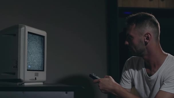 Mind Control - Zombified Man in White T-shirt schakelt kanalen op de tv — Stockvideo