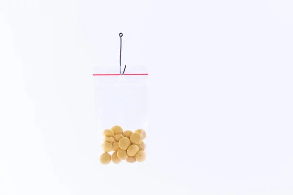Gekleurde pillen of tabletten opknoping in kleine Ziplock Bag op een vishaak — Stockfoto