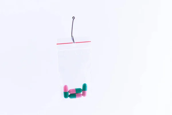 Colored Pills or Tablets Hanging in Small Ziplock Bag on a Fishing Hook — Stock Photo, Image