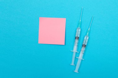 Aşı ya da Yeniden Aşılama Konsepti - Mavi Masaya İki Tıbbi Şırınga