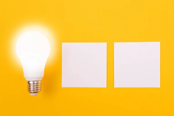 Eine Energiesparlampe mit weißem Zettelpapier — Stockfoto