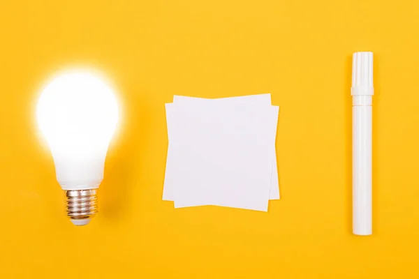 Glödande energisparlampa med vitbok — Stockfoto