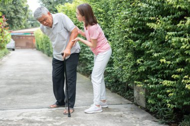 Arka bahçede yürüyen Asyalı son sınıf öğrencisi eklem iltihabı ve kasılma ağrıları ve eklem iltihabı (eklem iltihabı) ve kızı yardıma geldi. Eski sağlık sigortası ve sağlık sigortası kavramı