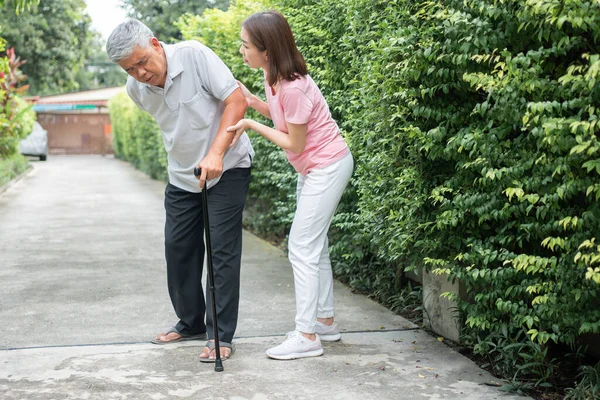 Arka bahçede yürüyen Asyalı son sınıf öğrencisi eklem iltihabı ve kasılma ağrıları ve eklem iltihabı (eklem iltihabı) ve kızı yardıma geldi. Eski sağlık sigortası ve sağlık sigortası kavramı