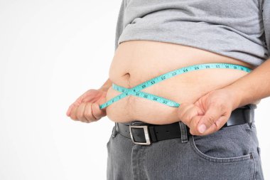 Kilolu adam göbeğini ölçmek için bir mezura kullanır. Beyaz arka planda izole edilmiş. Sağlık, ilaç ve kilo kaybı kavramı