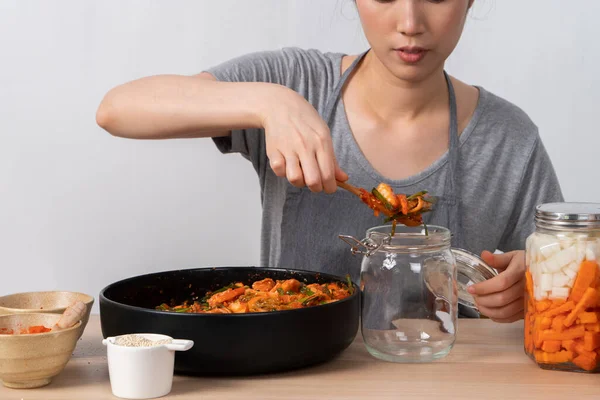 An Asian woman making kimchi and putting kimchi in bottles. After learning to cook at home — Stock Image Asian Woman Making Kimchi Putting Kimchi Bottles Learning Cook Home Stock Picture
